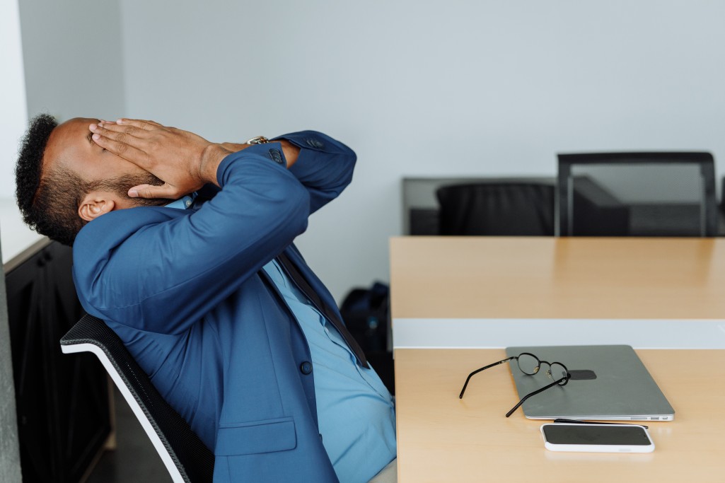 A stressed-out employee seated at his workspace.