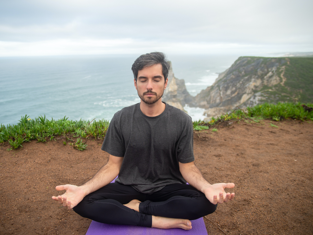 A man performing meditation outdoor.