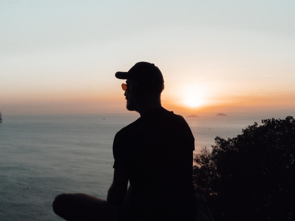 A silhouette image of a man relaxing by meditating