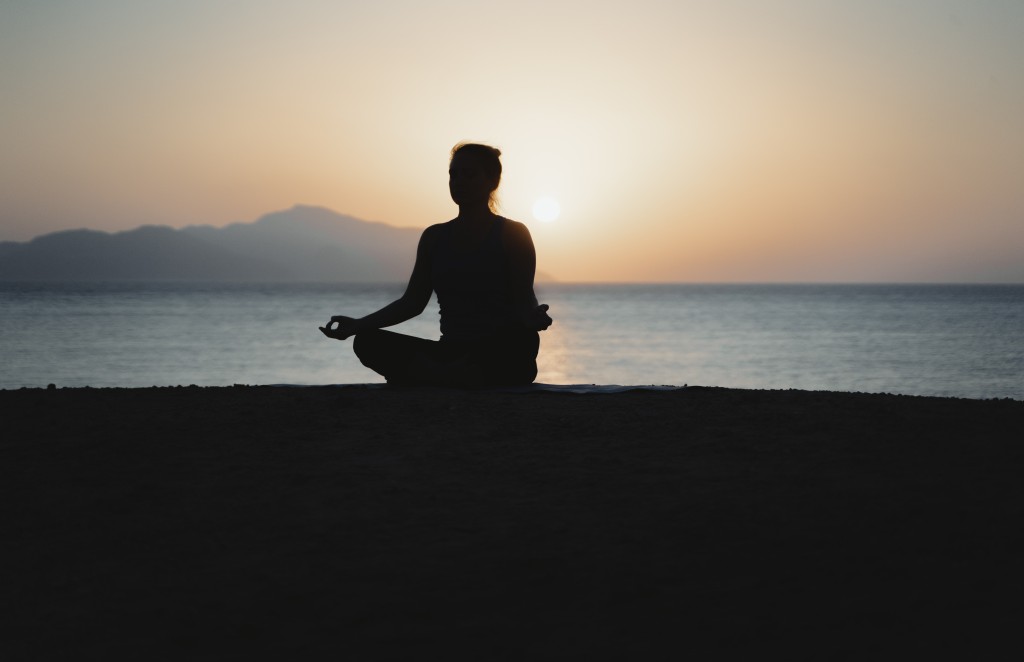 A silhouette image of woman meditating 