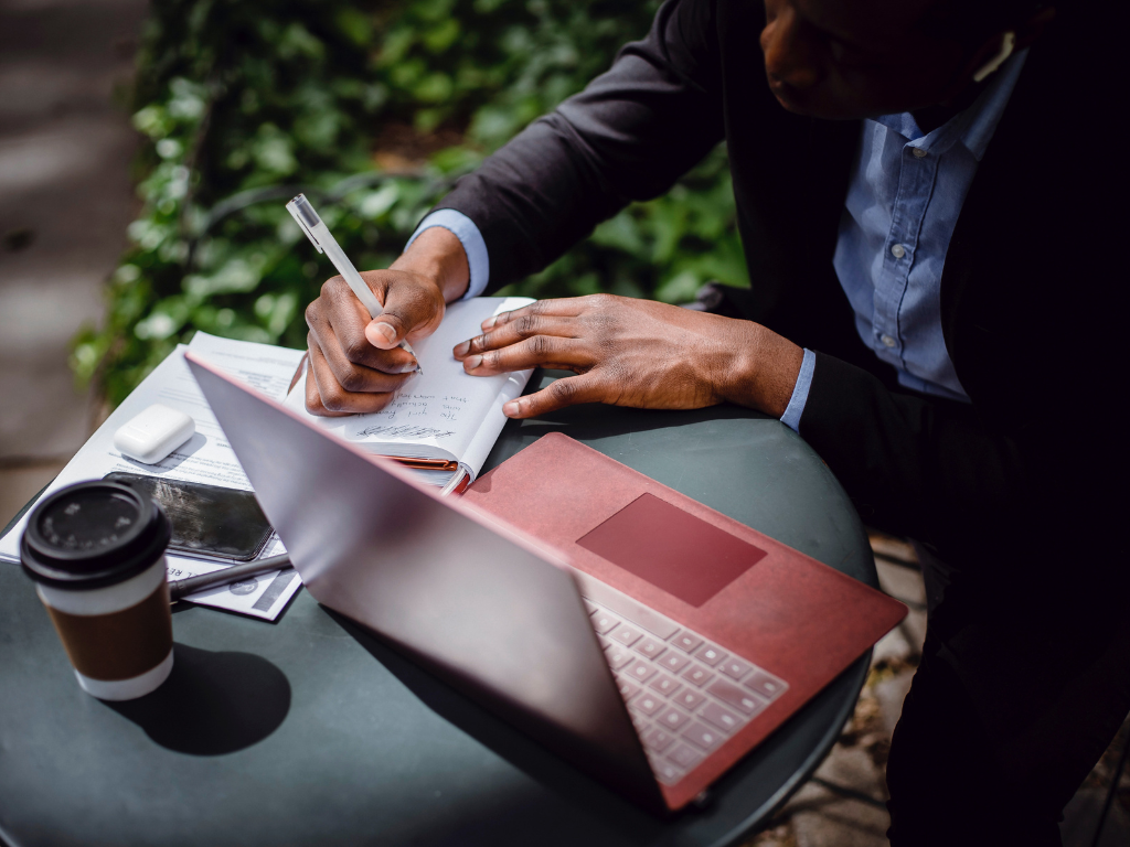 An image of busy man taking notes during work